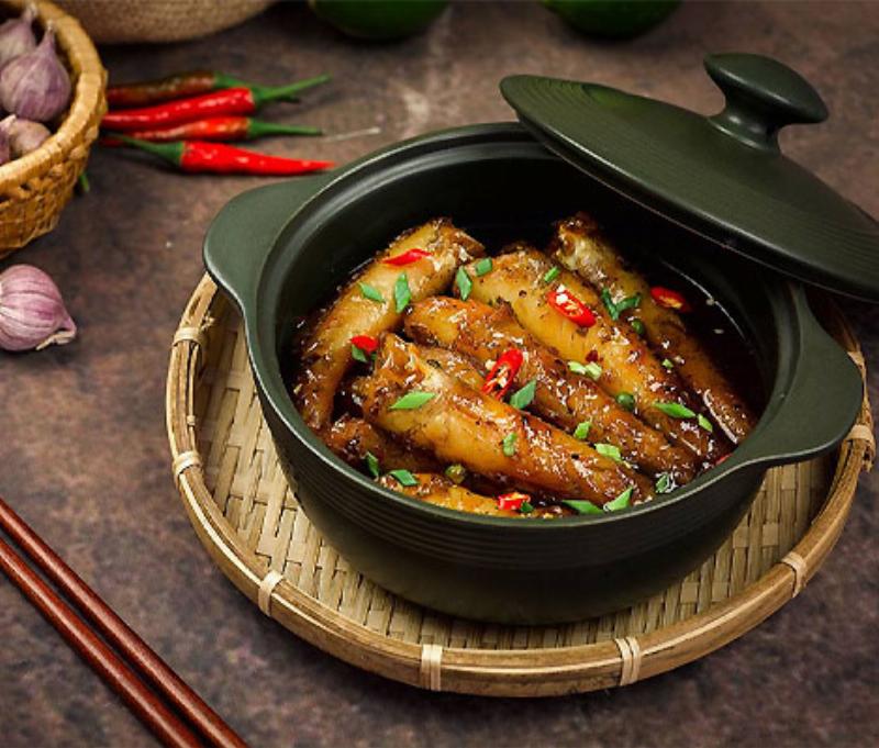 Nồi thịt kho nghệ đang được kho liu riu trên bếp, nước sốt sánh lại và thịt có màu vàng óng đẹp mắt
